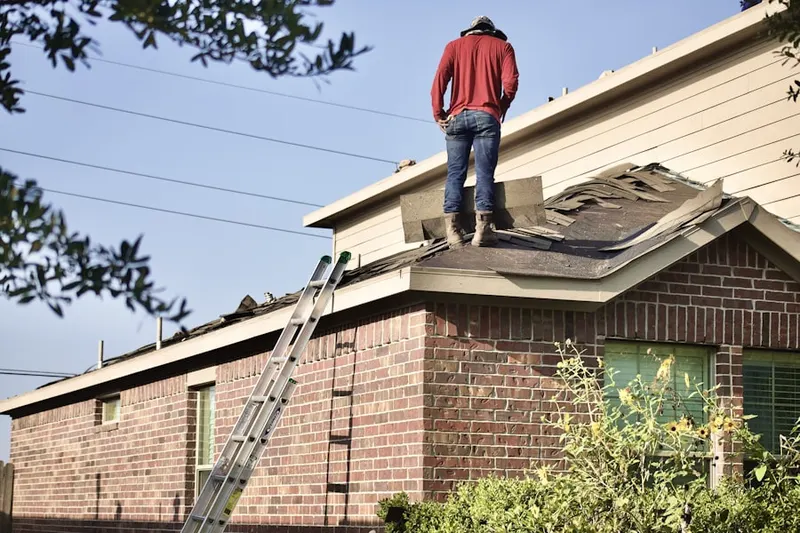 Professional roofer working on a residential roof in Aston Arms